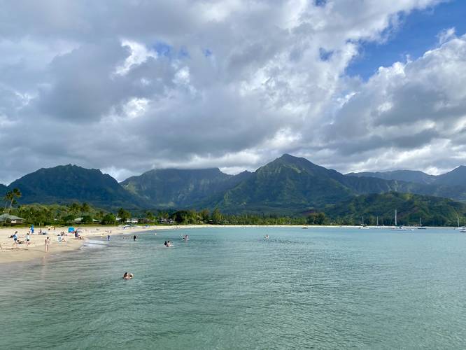 View of Hanalei Bay, docked boats, and surrounding mountains with a 2,800-foot waterfall cascading