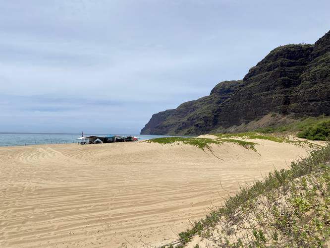 Beach campers at Polihale Beach with a view of the southern end of the Na Pali coastal cliffs