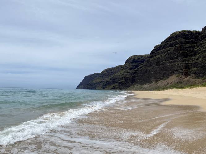 Ocean waves crash ashore at Polihale Beach, Polihale State Park with views of the southern end of the Na Pali coastal cliffs