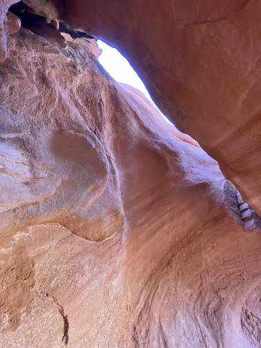 Light pours through a crack in the natural rock cave